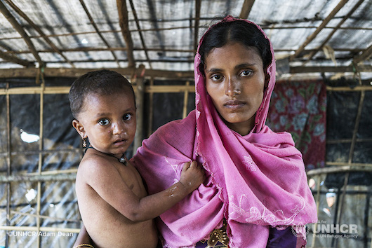 A Rohingya refugee holds her young daughter in a refugee camp.